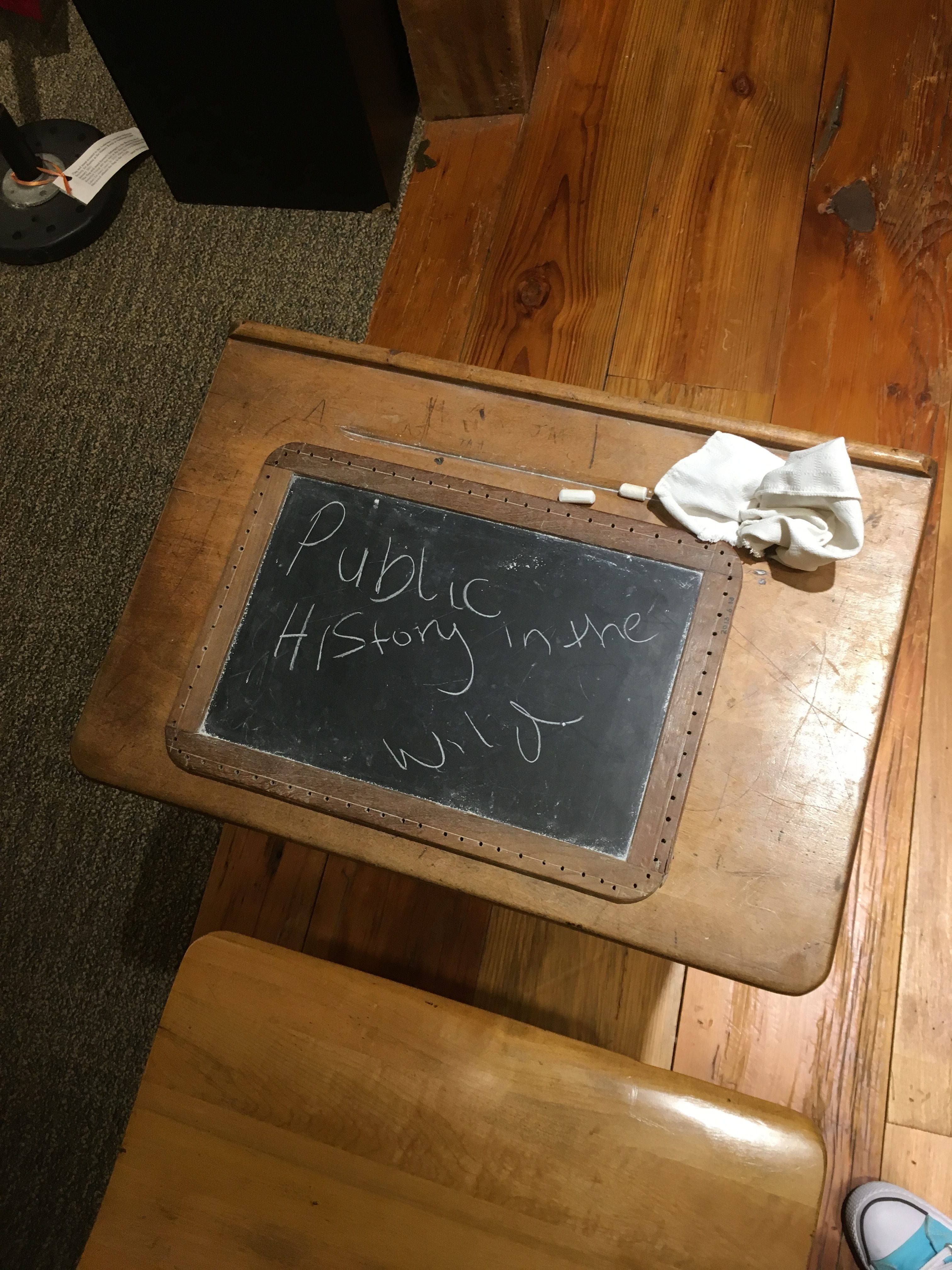 A school desk from a closed school with a chalkboard