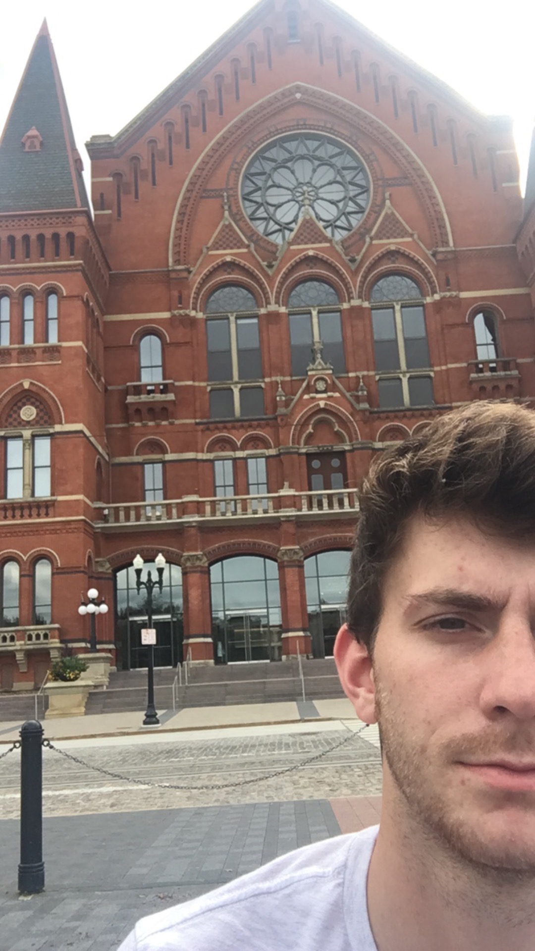 half a man's face in front of a large red brick building