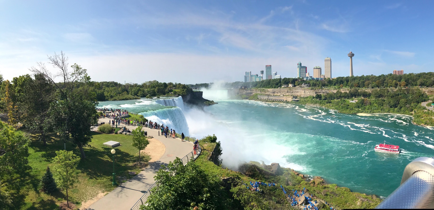 Photo showing the overview of the border between the USA and Canada with the waterfalls and tourists all around.