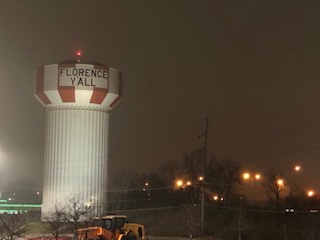 Water tower lit up at night.