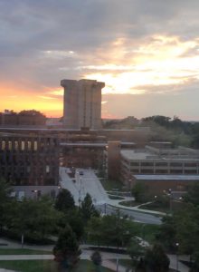 Crosley Tower, a large concrete building, pictured against a beautiful sunset.