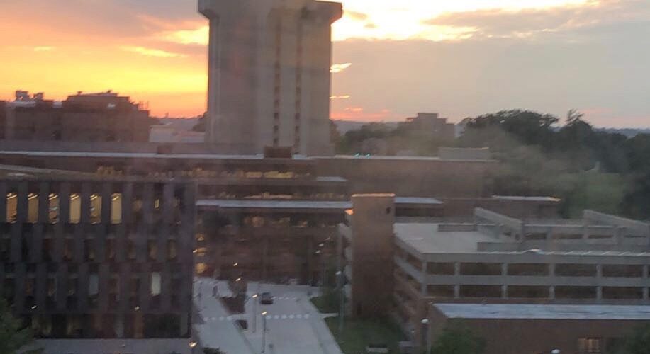 Crosley Tower, a large concrete building, pictured against a beautiful sunset.