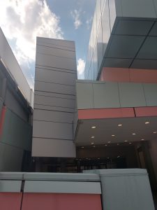 A cropped picture of the pastel blue and pink exterior of the DAAP Building