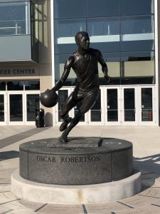 A statue of Oscar Robertson holding a basketball that is placed in front of the Fifth-Third Arena at the University of Cincinnati.