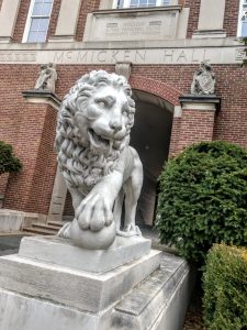 McMicken Hall lion, red brick building in background
