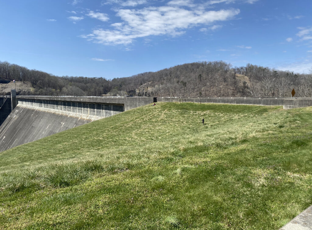 A picture of a grassy hill next to a large water dam