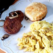 plate with biscuit, eggs, and sausage